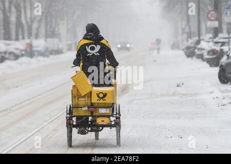 Berlin, Deutschland. Februar 2021, 08th. Ein Postbote der Deutschen Post fährt im Schnee entlang der Bölschestraße Friedrichshagen. Quelle: Kira Hofmann/dpa-Zentralbild/dpa/Alamy Live News Stockfoto