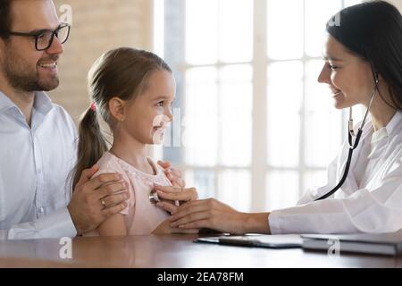 Caring weibliche Arzt untersuchen kleine Mädchen Patienten Herz Stockfoto