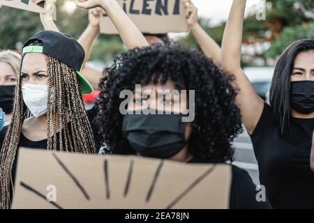 Menschen aus verschiedenen Kulturen und Rassen protestieren auf der Straße Für gleiche Rechte mit Sicherheitsmasken - Fokus auf links Frau Stockfoto