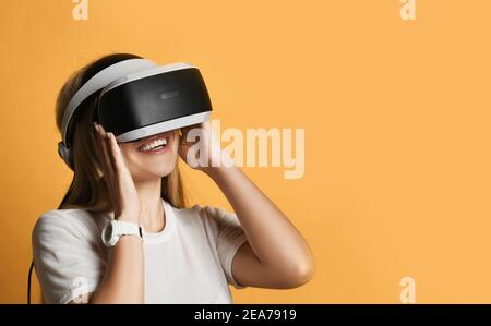 Portrait von glücklichen jungen blonden Frau in weißem T-Shirt mit VR-Brille zur Erforschung der erweiterten virtuellen Realität Stockfoto