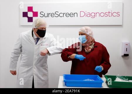 Premierminister Boris Johnson stößt bei einem Besuch von SureScreen Diagnostics in Derby bei einem Covid-19-Besuch auf Ellbogen mit einem Mitarbeiter. Bilddatum: Montag, 8. Februar 2021. Stockfoto