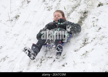 Amy Heather, 10 Jahre alt, Rodeln in der Nähe der Küste bei Southend-on-Sea in Essex. Das Met Office veröffentlichte schwere bernsteinfarbene Schneewarnungen für London und Südostengland, wo starker Schnee wahrscheinlich zu langen Verzögerungen auf den Straßen und bei Bahn- und Flugreisen führen wird. Bilddatum: Montag, 8. Februar 2021. Stockfoto