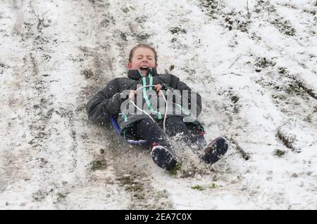 Amy Heather, 10 Jahre alt, Rodeln in der Nähe der Küste bei Southend-on-Sea in Essex. Das Met Office veröffentlichte schwere bernsteinfarbene Schneewarnungen für London und Südostengland, wo starker Schnee wahrscheinlich zu langen Verzögerungen auf den Straßen und bei Bahn- und Flugreisen führen wird. Bilddatum: Montag, 8. Februar 2021. Stockfoto