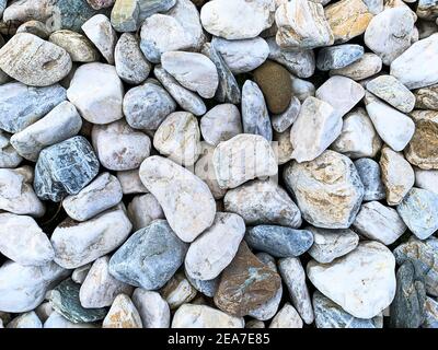 Hintergrund aus mehrfarbigen Steinen unterschiedlicher Form. Stockfoto