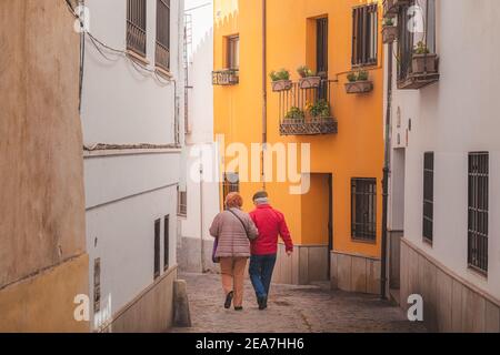 Granada, Spanien - April 1 2018: Ein älteres Ehepaar aus der Region genießt einen ruhigen Sonntagsbummel auf den malerischen, engen Kopfsteinpflasterstraßen in der Altstadt (Albaicin oder A Stockfoto