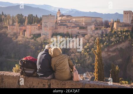 Granada, Spanien - April 1 2018: Ein Paar genießt einen romantischen Blick bei Sonnenaufgang golden auf die ikonische Alhambra vom Mirador de San Nicolas in der Altstadt von Gran Stockfoto