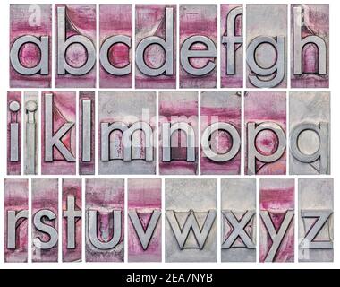 Englisches Alphabet - eine Collage aus 26 isolierten Kleinbuchstaben in grunge Buchdruck Metall-Typ, zerkratzt und mit lila Tinte gefärbt Stockfoto