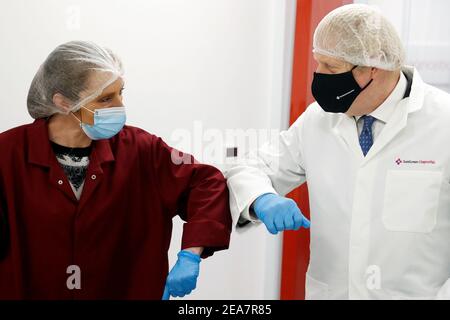 Premierminister Boris Johnson stößt bei einem Besuch von SureScreen Diagnostics in Derby bei einem Covid-19-Besuch auf Ellbogen mit einem Mitarbeiter. Bilddatum: Montag, 8. Februar 2021. Stockfoto