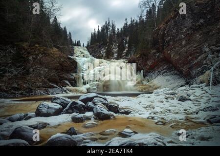 Gefrorener Wasserfall im norwegischen Wald. Homla Fluss in Norwegen. Kaltes, frostiges Winterwetter. Schnee und Eis im Wald. Mettifossen Wasserfall. Stockfoto