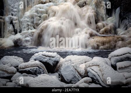 Gefrorener Wasserfall im norwegischen Wald. Homla Fluss in Norwegen. Kaltes, frostiges Winterwetter. Schnee und Eis im Wald. Mettifossen Wasserfall. Stockfoto