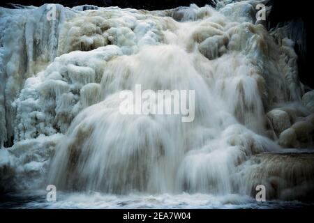 Gefrorener Wasserfall im norwegischen Wald. Homla Fluss in Norwegen. Kaltes, frostiges Winterwetter. Schnee und Eis im Wald. Mettifossen Wasserfall. Stockfoto