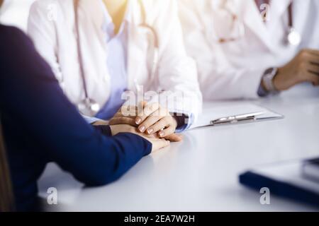 Unbekannte Frau-Arzt beruhigende weibliche Patientin, Nahaufnahme. Empathie imedicine während Coronavirus Pandemie. Covid 2019 Stockfoto