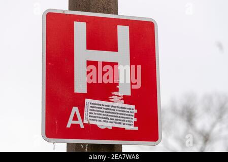 Southend University Hospital, Essex, Großbritannien. Februar 2021, 8th. Auf einem ‘H’ A&E-Schild vor dem Southend University Hospital wurde ein Aufkleber mit einer Anti-vax-Falschinformation angebracht, die auf das COVID 19, das Impfprogramm gegen Coronaviren, für das das Krankenhaus ein Zentrum ist, abzielt. Die Förderung ‘von „Fake News“ war ein ernstes Problem während der Arbeit, die Pandemie zu besiegen. Die Weiße Rose ist eine Organisation, die den Widerstand gegen das Tragen von Masken und soziale Distanzierung fördert und gegen Lockdown ist Stockfoto