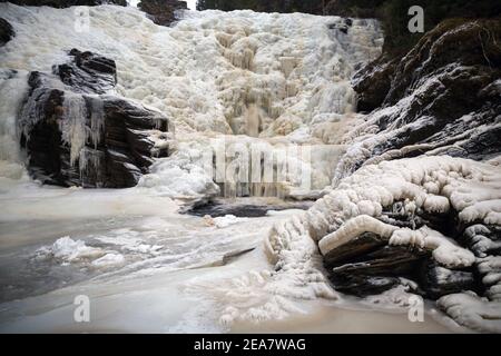 Gefrorener Wasserfall im norwegischen Wald. Homla Fluss in Norwegen. Kaltes, frostiges Winterwetter. Schnee und Eis im Wald. Dolandfossen Wasserfall. Stockfoto