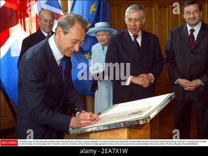 Der sozialistische Bürgermeister von Paris, Bertrand Delanoe, unterzeichnet das Goldbuch, während die britische Königin Elizabeth, der Herzog von Edinburgh und der britische Außenminister Jack Straw am Dienstag, den 6. April 2004 im Rathaus stehen. Am 2nd. Tag eines 3-tägigen Staatsbesuchs in Frankreich anlässlich des 100. Jahrestages des Abkommens von Entente Cordiale, das den Rivalitäten der Kolonialzeit zwischen den beiden Ländern ein Ende setzte. Foto von Mousse-Hounsfield/ABACA. Stockfoto