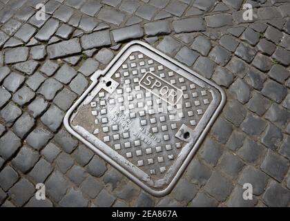 SPQR-Schriftzug auf einem Inspektionsdeckel in einer gepflasterten Straße in Rom, Italien bedeutet Regierungseigentum der alten römischen Republik. Stockfoto