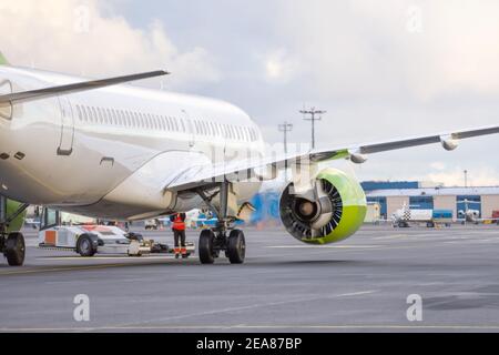 Das Flugzeug schiebt den Schlepper vor dem Starten der Motoren und Rollen, Rückansicht Stockfoto