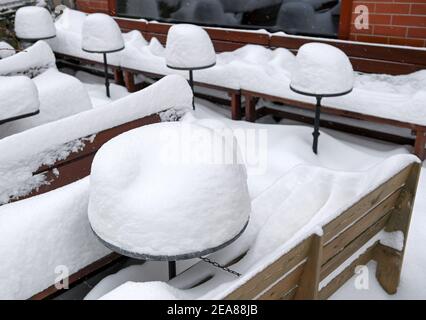 08. Februar 2021, Sachsen-Anhalt, Halle (Saale): Schnee liegt auf Tischen und Bänken eines Cafés in der Kneipenmeile Halle/Saale. Starker Schneefall führt zu erheblichen Behinderungen auf Straßen, Eisenbahnen und Fußwegen. Foto: Hendrik Schmidt/dpa-Zentralbild/ZB Stockfoto