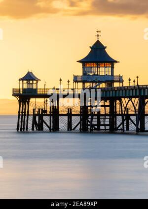 Clevedon Pier wunderschön hinterleuchtet mit einem goldenen Sonnenuntergang Stockfoto