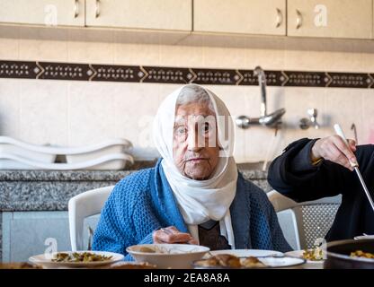 Alte Frau, die in der Küche isst Stockfoto