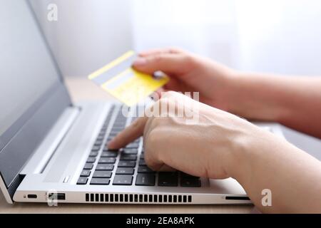 Frau mit Kreditkarten-Typen auf Laptop-Tastatur. Konzept von Online-Shopping und Zahlung, Finanztransaktionen Stockfoto