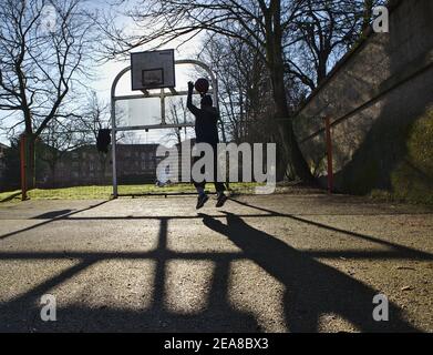 Junger Mann spielt Basketball allein Stockfoto