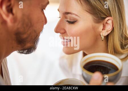 Liebevolles Paar mit Tassen gefüllt mit einem heißen Getränk Stockfoto