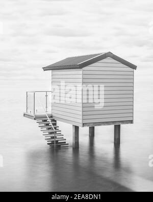 Eine Strandhütte auf Stelzen bei Flut Blick auf das Meer in Essex Stockfoto