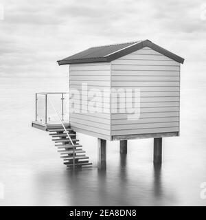 Eine Strandhütte auf Stelzen bei Flut Blick auf das Meer in Essex Stockfoto