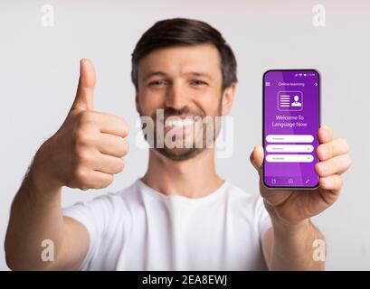 Online Learning Application. Lächelnder Mann Empfiehlt Pädagogische App Auf Smartphone, Kreative Collage Stockfoto