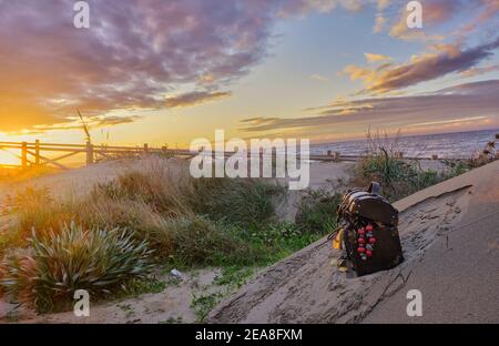 Schatzkiste am Strand bei Sonnenaufgang, Juwelen und Goldmünzen Stockfoto