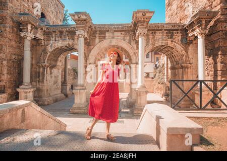 Glückliche weibliche Touristen entdecken interessante Orte und beliebte Sehenswürdigkeiten und Spaziergänge in der Altstadt von Antalya, Türkei. Das berühmte römische Tor Stockfoto