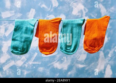 Blau und orange sauber gewaschen Socken hängen auf Wäscheleine zu Trocken Stockfoto
