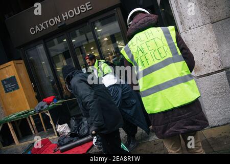 London, Großbritannien. Februar 2021, 08th. Stopp HS2 Protestierende schaffen einen Mock-up-Tunnel beim Health and Safety Executive, London, UK. Die Agentur ist verantwortlich für die Gewährleistung der Gesundheit und Sicherheit der Euston-Platz Räumung, die Demonstranten sagen, ist unsicher, 8th. Februar 2021. Das Anti-HS2-Lager wird weiterhin von Gerichtsvollzieher (vom National Enforcement Team, NET, einer Tochtergesellschaft der High Court Enforcement Group) am Bahnhof Euston geräumt (um einen temporären Parkplatz zu schaffen). Alle oben genannten Demonstranten wurden geräumt und beginnen nun, um die Tunnel herum zu graben. Kredit: Denise Laura Baker/ Stockfoto