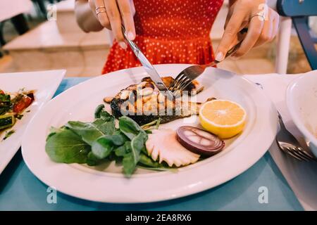 Frau essen gebratenes Lachssteak im Restaurant. Stockfoto