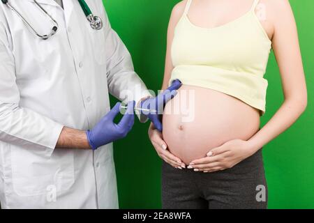 Konzept der Neugeborenen-Familie. Eine schwangere Frau mit der Hand eines Arztes zu impfen, Krankenschwester impfen junge Mädchen mit einem Kind oder jungen Entwicklung in th Stockfoto