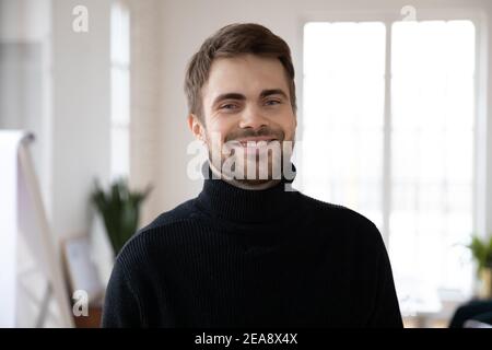Glücklich gut aussehend männlich Millennial posiert in weißen Innenraum Stockfoto