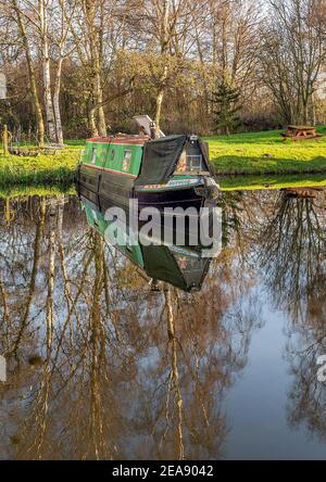 Melbourne, East Yorkshire, UK, 01/12/2020 - Canal Narrow Boote in Melbourne Arm in sonnigen Tag mit Reflexionen im stillen Wasser festgemacht. Stockfoto