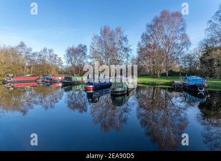 Melbourne, East Yorkshire, UK, 01/12/2020 - Canal Narrow Boote in Melbourne Arm in sonnigen Tag mit Reflexionen im stillen Wasser festgemacht. Stockfoto