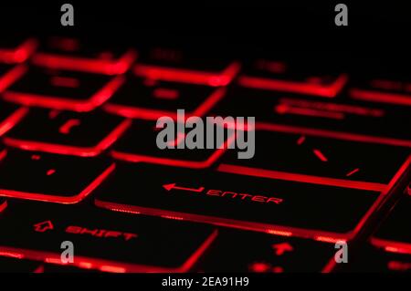 Enter-Taste. Rote Hintergrundbeleuchtung, Hintergrundbeleuchtung auf Gaming-Laptops Computer im Dunkeln. Nahaufnahme Stockfoto