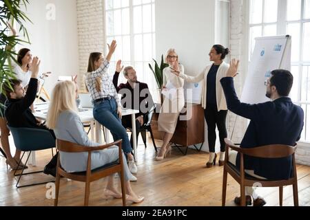 Motivierte Mitarbeiter, die die Hände heben, den Coach beim Training fragen. Stockfoto