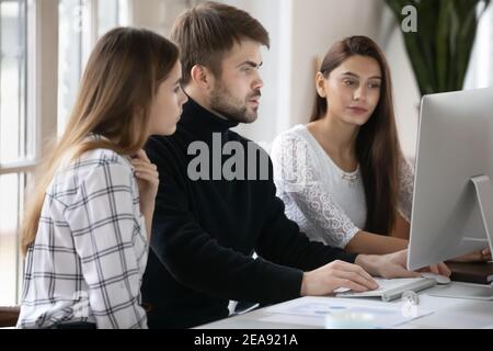 Gruppe von Geschäftsleuten, die zusammen am Computer arbeiten Stockfoto