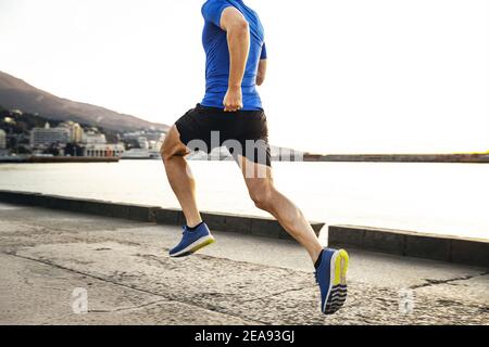 Zurück männlichen Läufer laufen am Morgen entlang Seemandag in Stadt Stockfoto