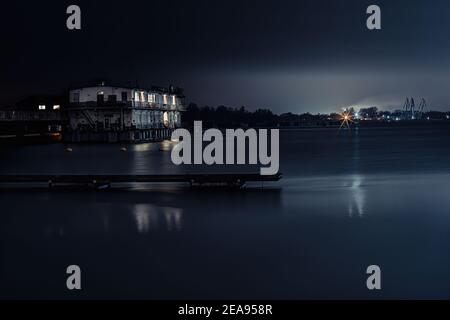 Perspektivischer Blick auf einen hölzernen Pier auf dem Teich bei Sonnenuntergang mit perfekt spiegelnde Reflexion Stockfoto