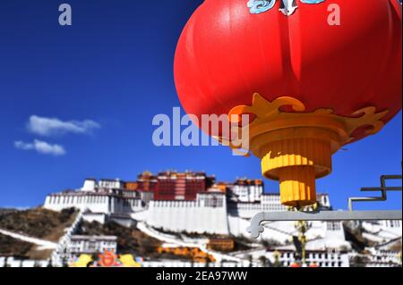 Lhasa, Chinas Autonome Region Tibet. Februar 2021, 8th. Eine rote Laterne ist vor dem Potala Palast in Lhasa, der Hauptstadt der Autonomen Region Tibet im Südwesten Chinas, zu sehen, 8. Februar 2021. Sowohl das Frühlingsfest als auch das tibetische Neujahr fallen in diesem Jahr auf den 12. Februar. Quelle: Chogo/Xinhua/Alamy Live News Stockfoto