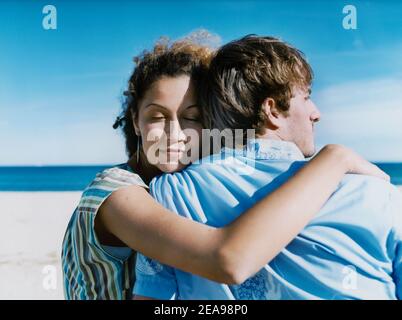 Gerade Paar umarmt am Strand Stockfoto