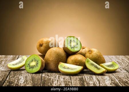 Kiwi Früchte mit Scheiben auf Holztisch Stockfoto