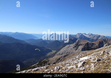 Wanderung zur Pleisenspitze (2569m), Gleitschirm, vor dem Brunnsteinmassiv, in der Mitte hinter dem Wettersteingebirge, im Hintergrund die Zugspitze, Bergtour, Bergwandern, Outdoor, im Tal sieht man Scharnitz, links der Blick ins Inntal Stockfoto