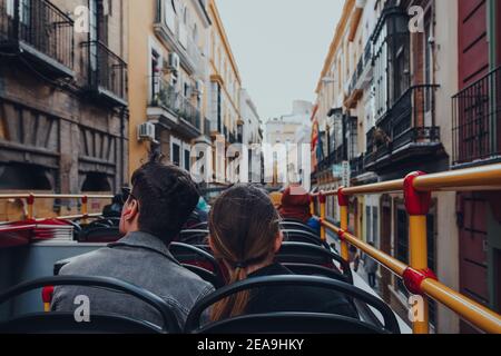 Sevilla, Spanien - 19. Januar 2020: Rückansicht eines Paares auf Tour Bus fahren durch eine enge Straße in Sevilla, Hauptstadt der Region Andalusien in Stockfoto