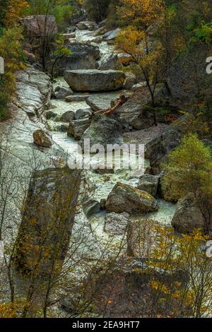 Gebirgsfluss fließt schnell und ungestüm zwischen großen Felsbrocken. Nationalpark Maiella, Abruzzen, Italien Stockfoto